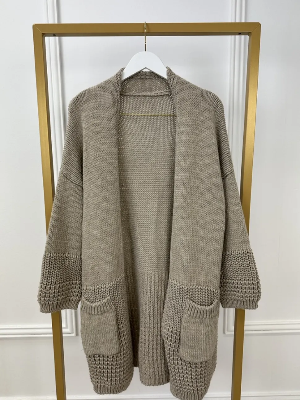 grof_gebreid_vest_met_zak_0-3.webp Grof gebreid vest met zakken en patroon op de mouw taupe